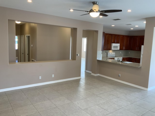 kitchen featuring white appliances, baseboards, visible vents, decorative backsplash, and a sink