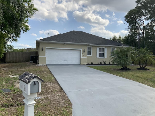 ranch-style house featuring driveway, stucco siding, an attached garage, fence, and a front yard