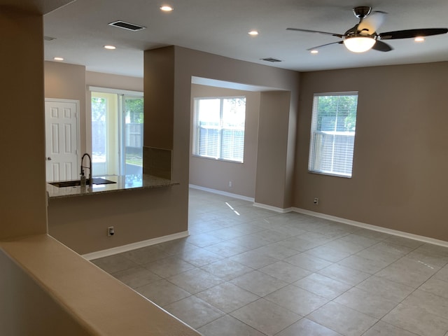 spare room with light tile patterned floors, visible vents, baseboards, a sink, and recessed lighting