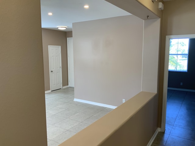 hall with light tile patterned floors, recessed lighting, and baseboards