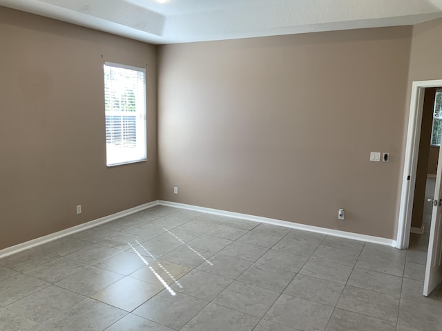 unfurnished room featuring baseboards and light tile patterned floors