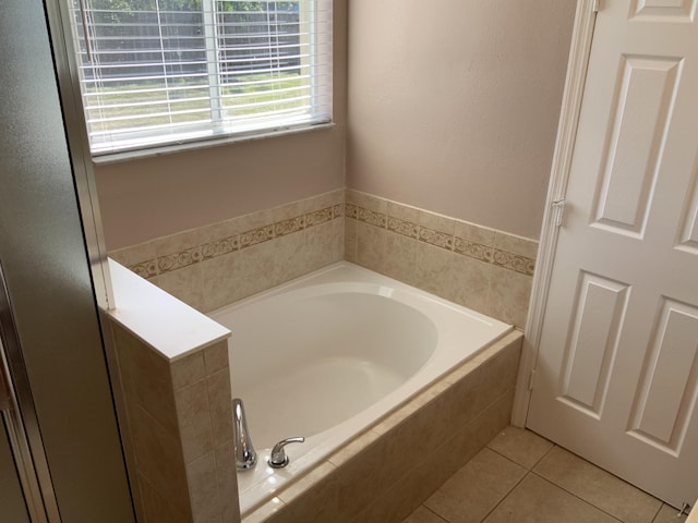 bathroom featuring tile patterned flooring and a bath