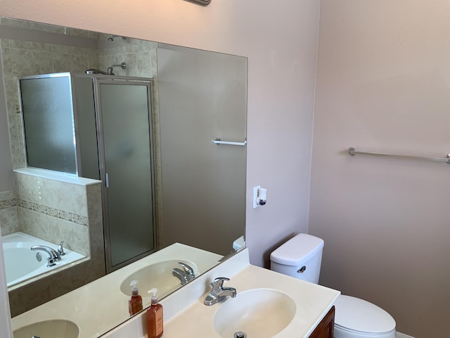 bathroom featuring toilet, a garden tub, a shower stall, and vanity