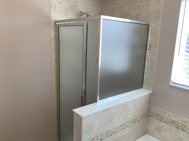 bathroom featuring a garden tub and a shower stall