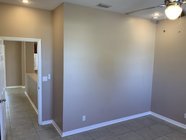 unfurnished room featuring light tile patterned floors, baseboards, visible vents, and ceiling fan