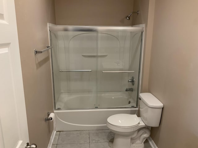 bathroom with bath / shower combo with glass door, baseboards, toilet, and tile patterned floors