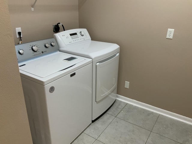 laundry room featuring laundry area, independent washer and dryer, baseboards, and light tile patterned floors