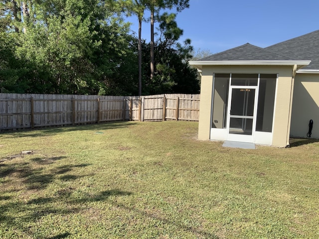 view of yard with a sunroom and a fenced backyard