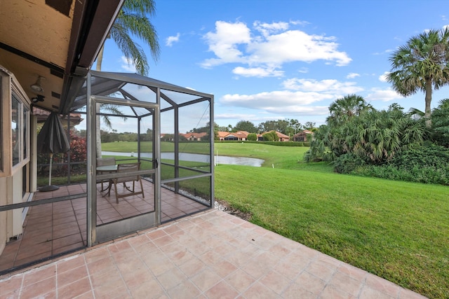 view of patio / terrace featuring a lanai and a water view