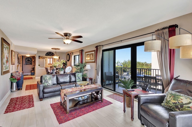 living room featuring light hardwood / wood-style flooring, a wealth of natural light, and ceiling fan