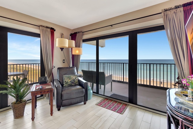 interior space featuring a beach view, a water view, and light hardwood / wood-style floors