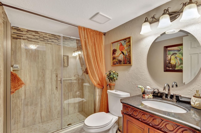 bathroom with a textured ceiling, vanity, toilet, and a shower with shower door