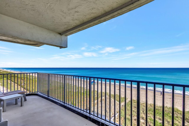 balcony with a water view and a beach view