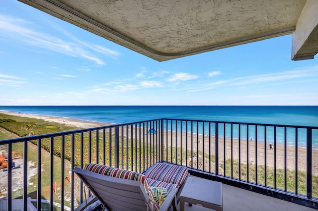 balcony featuring a beach view and a water view