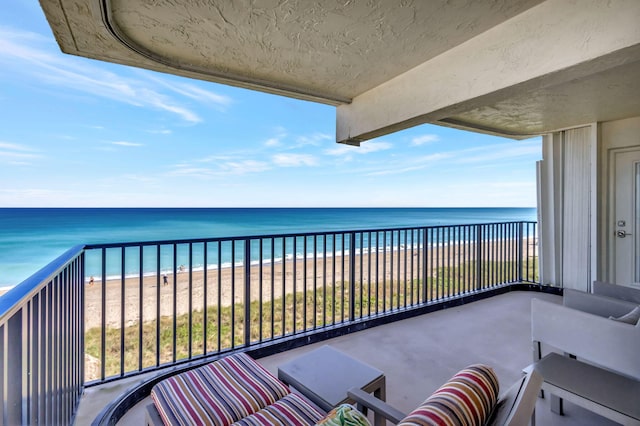 balcony with a water view and a beach view