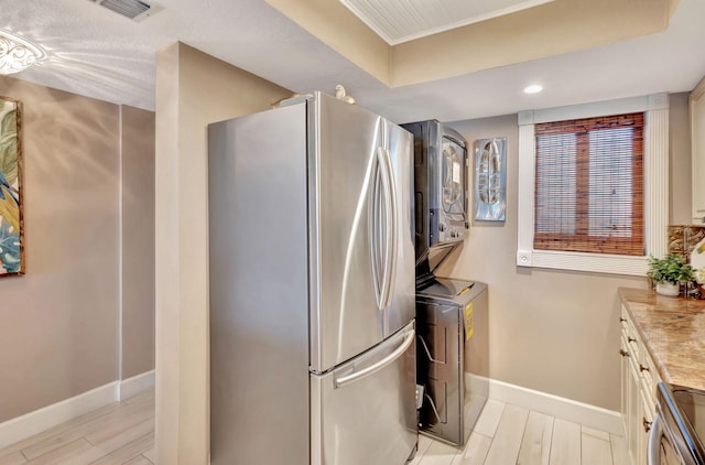 interior space with vanity, stacked washer and clothes dryer, and hardwood / wood-style flooring