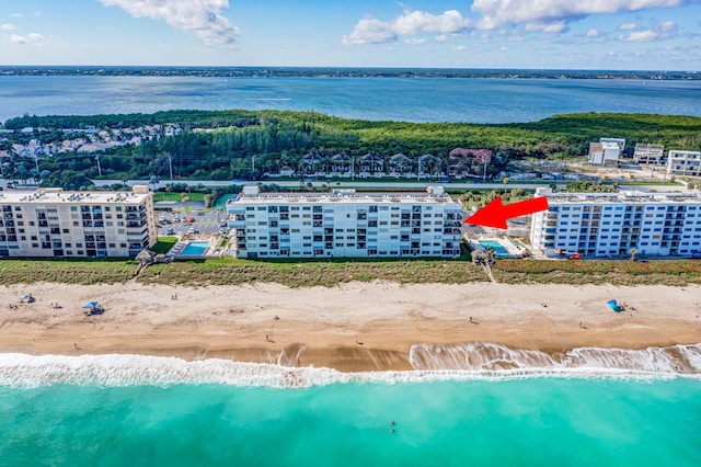 birds eye view of property with a water view and a beach view