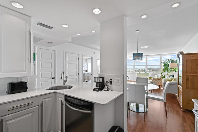 kitchen featuring white cabinets, light stone counters, kitchen peninsula, and sink