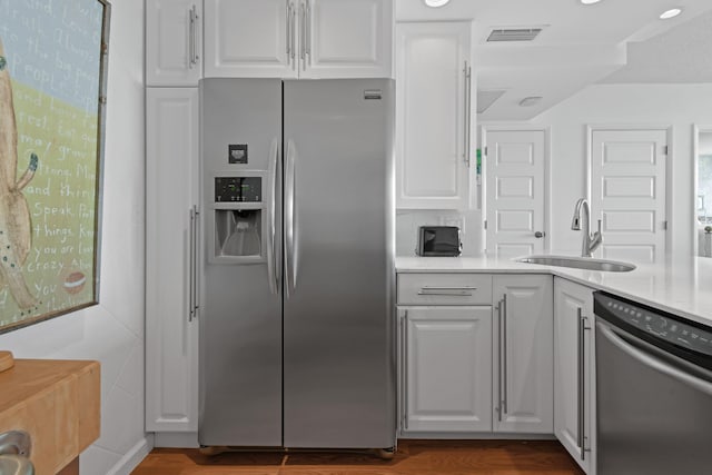 kitchen with white cabinetry, sink, and stainless steel appliances