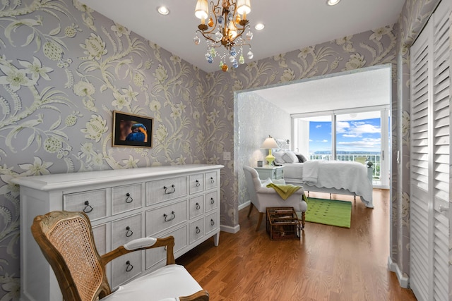 bedroom featuring access to outside, a chandelier, and wood-type flooring