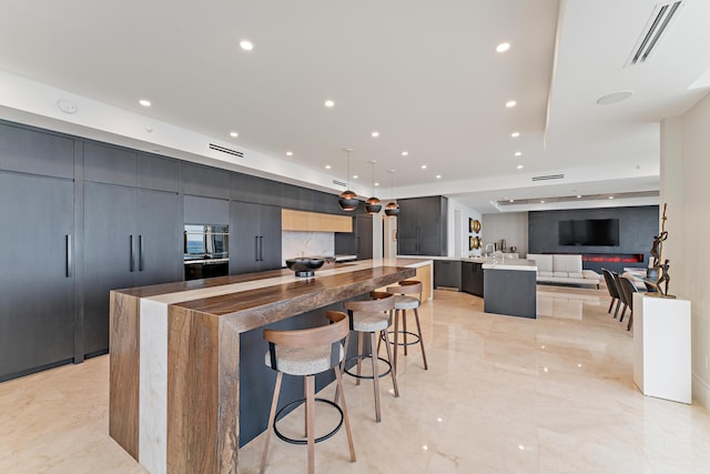 kitchen featuring a kitchen bar, decorative light fixtures, and a spacious island