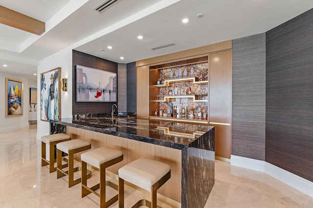 bar with built in shelves and dark stone counters