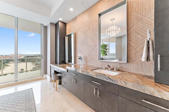 bathroom featuring vanity, a wall of windows, and an inviting chandelier