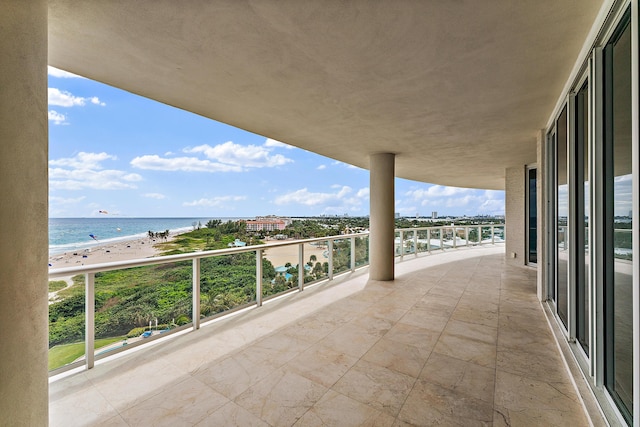 balcony featuring a view of the beach and a water view