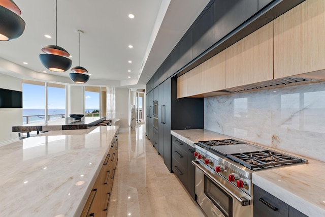 kitchen with decorative backsplash, light brown cabinetry, light stone counters, pendant lighting, and stainless steel stove