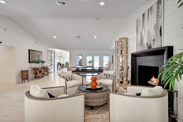 living room with wood walls, a fireplace, and vaulted ceiling