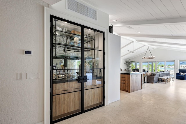 interior space featuring vaulted ceiling with beams, decorative light fixtures, and a chandelier