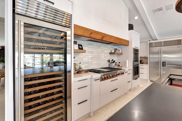 kitchen with white cabinets, stainless steel appliances, wine cooler, and tasteful backsplash