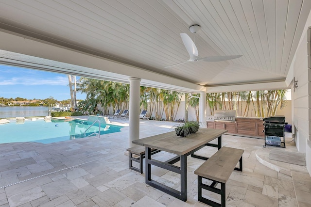 view of swimming pool with ceiling fan, area for grilling, a water view, and a patio