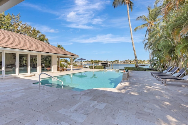 view of pool with a water view and a patio