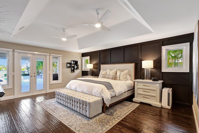 bedroom featuring ceiling fan, french doors, dark hardwood / wood-style flooring, a tray ceiling, and access to outside