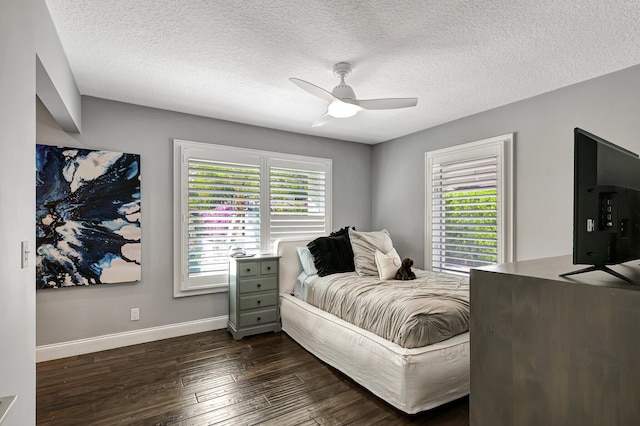 bedroom with a textured ceiling, ceiling fan, and dark wood-type flooring