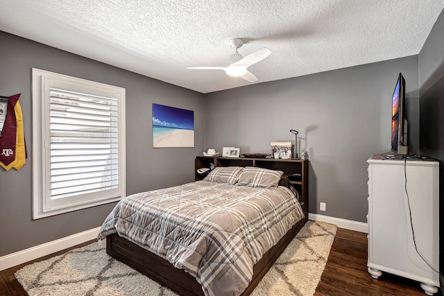 bedroom with ceiling fan, dark hardwood / wood-style flooring, and a textured ceiling