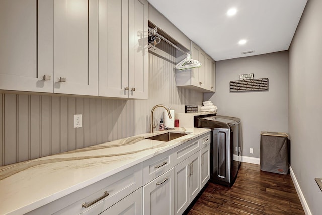 laundry room with separate washer and dryer, sink, cabinets, and dark wood-type flooring