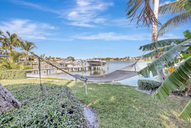 view of dock with a yard and a water view