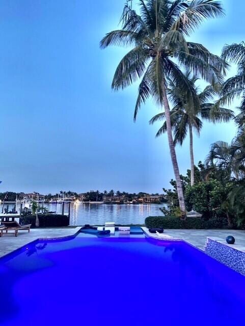 view of swimming pool featuring a water view and a patio