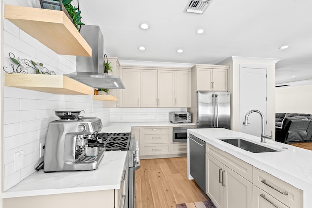 kitchen with island exhaust hood, appliances with stainless steel finishes, tasteful backsplash, light stone counters, and sink