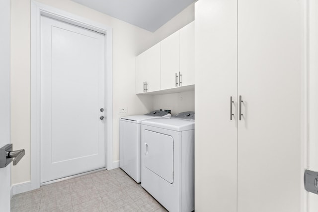 clothes washing area with cabinets and washer and clothes dryer