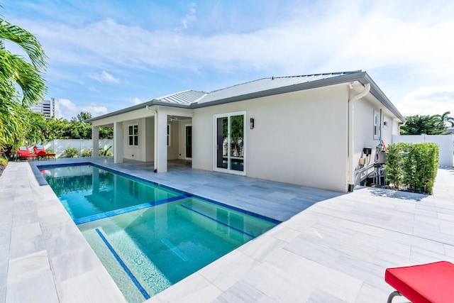 back of property featuring a patio and a fenced in pool