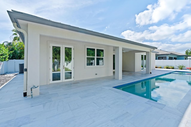 rear view of house with a patio area, a fenced in pool, and french doors