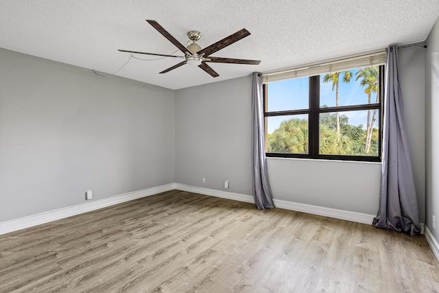 spare room with ceiling fan, light wood-type flooring, and a textured ceiling