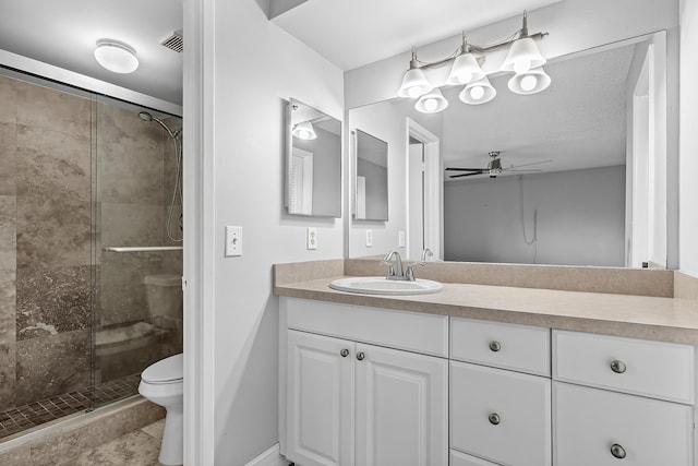 bathroom featuring ceiling fan, toilet, a shower with door, and vanity