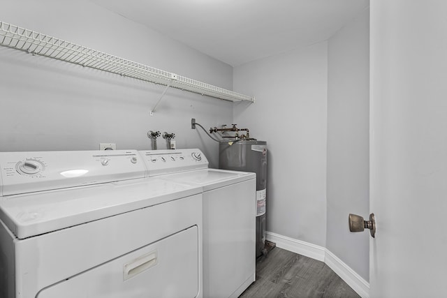 laundry room with washer and clothes dryer, dark hardwood / wood-style floors, and electric water heater