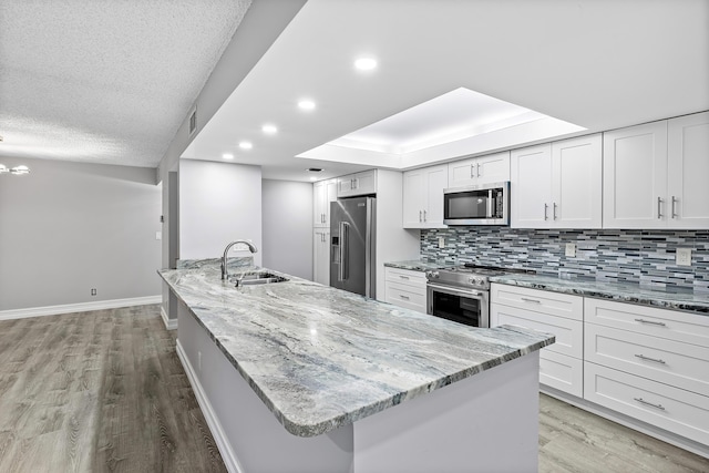 kitchen featuring light hardwood / wood-style flooring, stainless steel appliances, white cabinetry, and sink