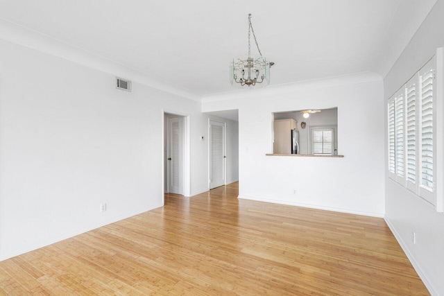 interior space featuring ornamental molding, a chandelier, and light hardwood / wood-style flooring