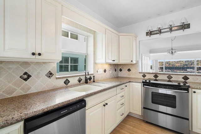 kitchen featuring cream cabinets, sink, ceiling fan, light wood-type flooring, and appliances with stainless steel finishes